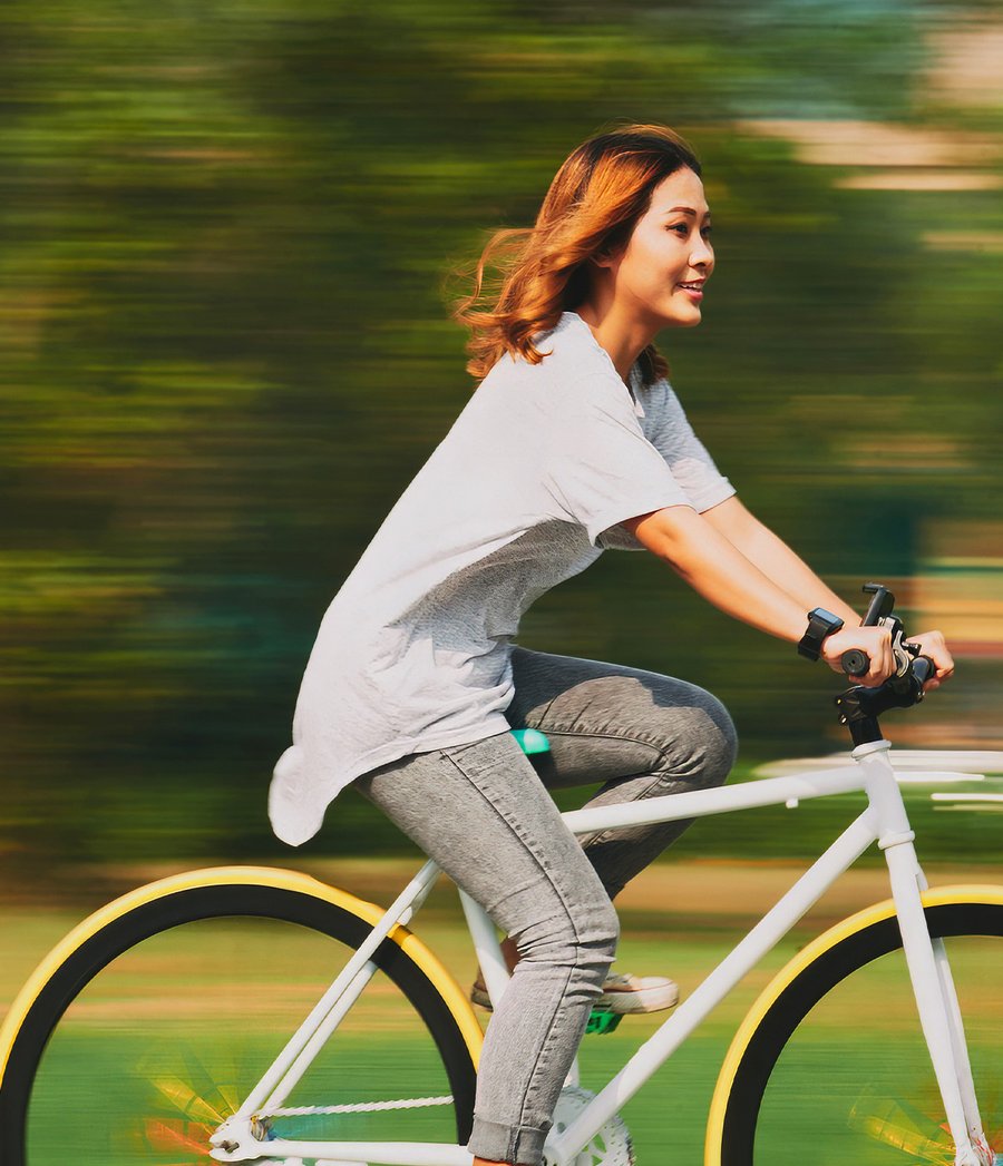 Femme à vélo souriante sur une piste cyclable