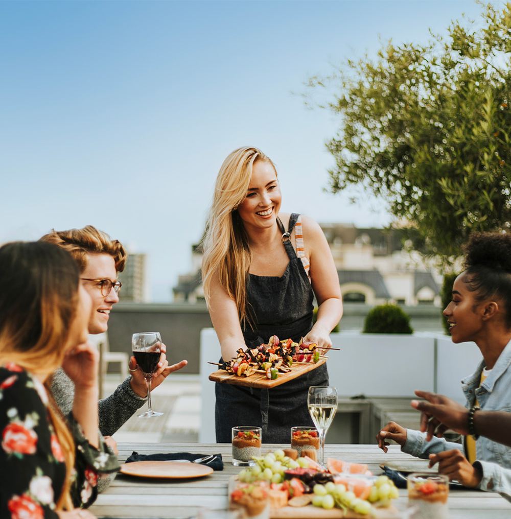 Amis partageant un repas convivial sur une terrasse extérieure