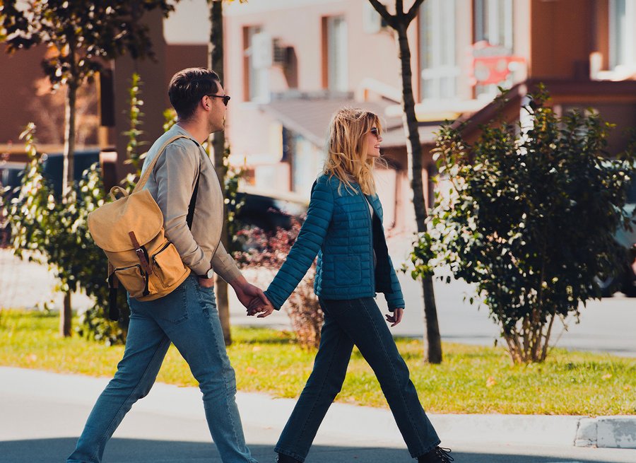 Couple marchant main dans la main dans un quartier résidentiel